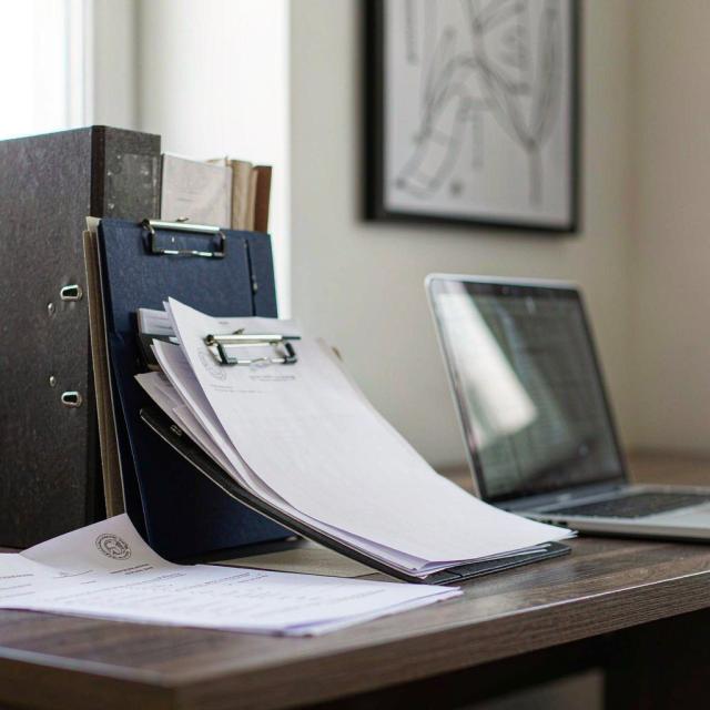 Waste transfer notes, duty of care records and reporting spreadsheets on a desk in a UK office