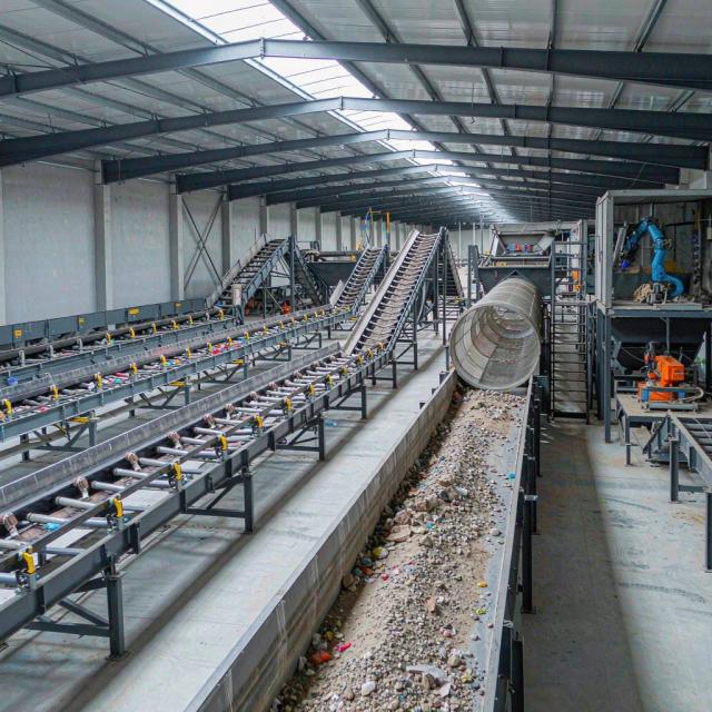Conveyors and screening equipment inside a materials recovery facility sorting recyclable streams